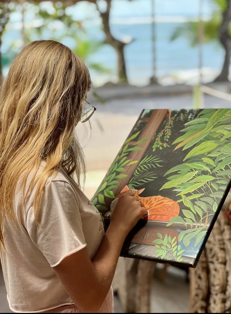 Guest painting a rainforest-inspired artwork during an art class
