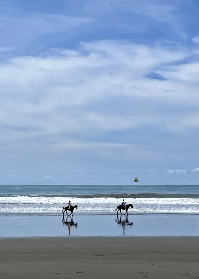 Horseback riders on a quiet beach