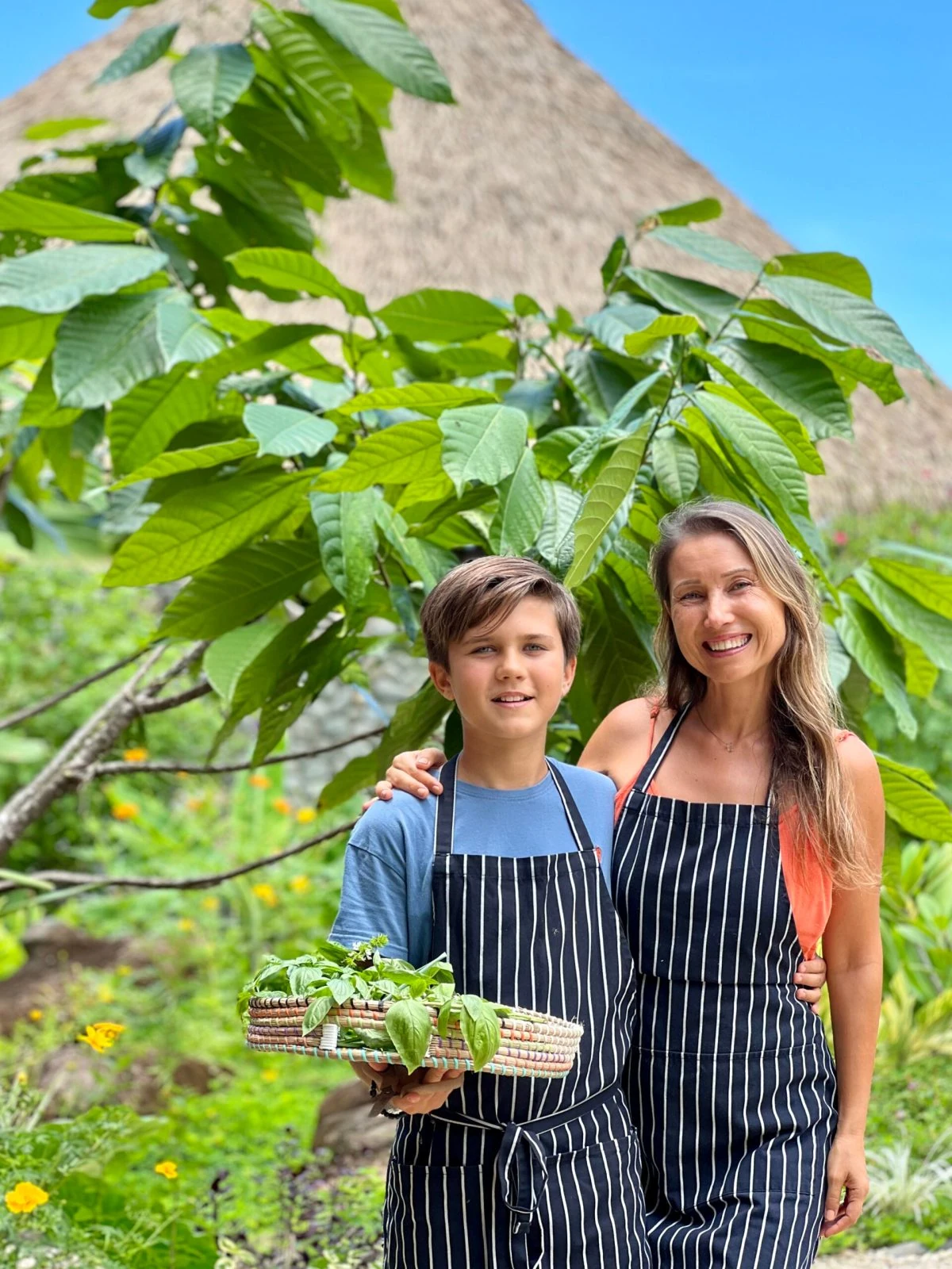 Lena and Leo with freshly harvested ingredients in the rainforest kitchen