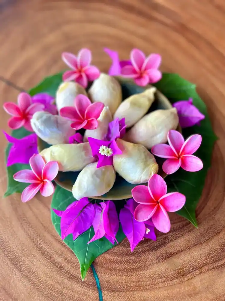Freshly harvested tropical fruit with pink blossoms
