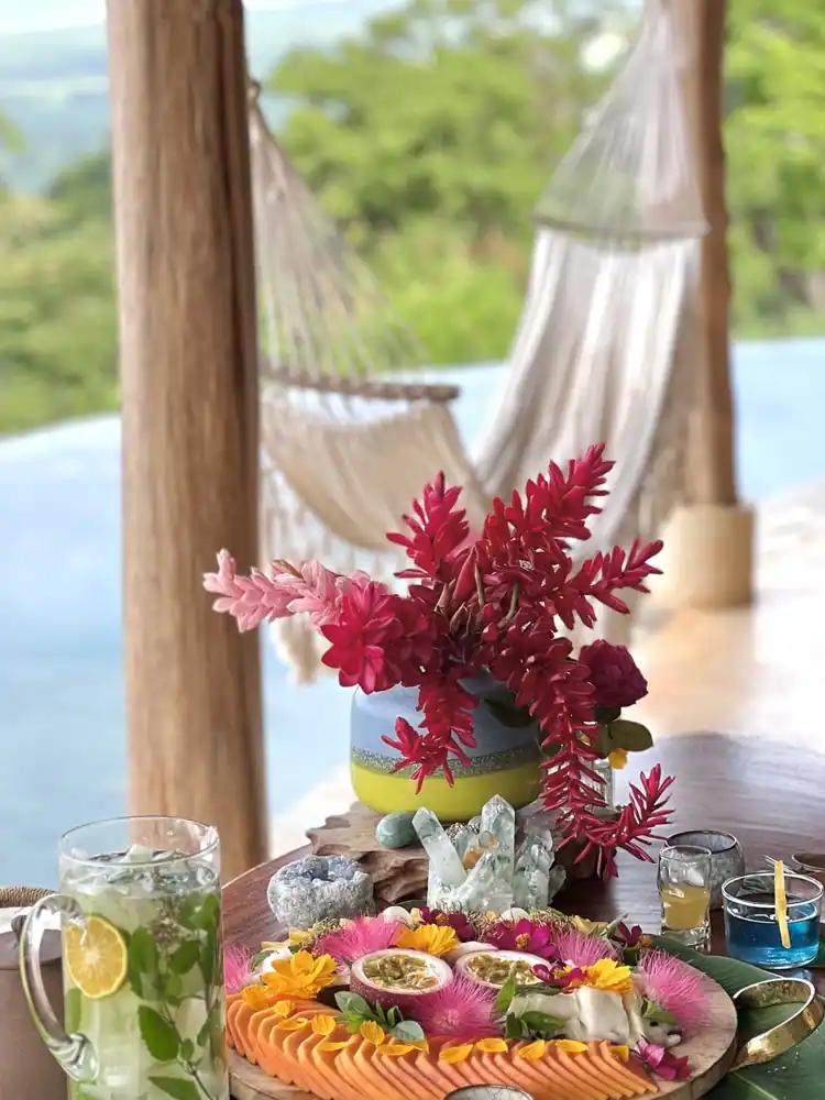 Fresh flowers, garden fruit, and herbal drinks beside the infinity pool